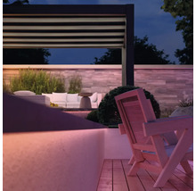 Ambiance de jardin avec pergola, meubles de salon et terrasse en bois au crépuscule