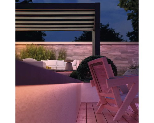 Ambiance de jardin avec pergola, meubles de salon et terrasse en bois au crépuscule