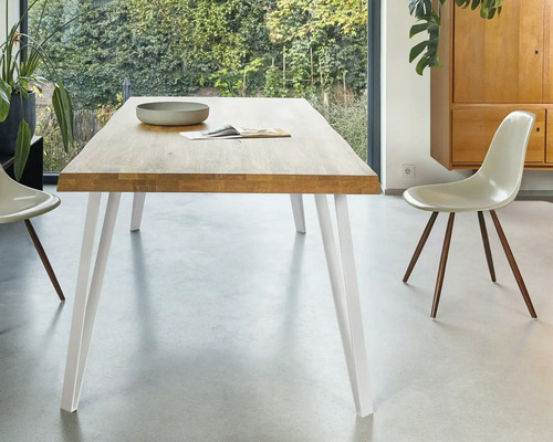 Table de salle à manger avec plateau en bois et pieds blancs dans la salle à manger.