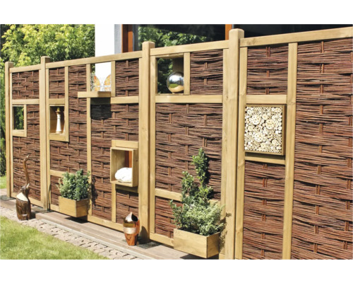 Clôture décorative en osier avec étagères et décorations dans le jardin