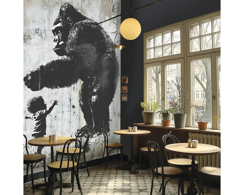 Innenraum eines Cafés mit einem Wandbild eines Gorillas und einem Kind, Tischen und Stühlen.