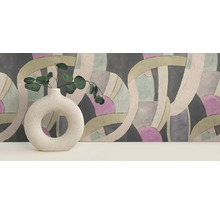 Dekorative Szene mit einer Vase mit Eukalyptus vor einer gemusterten Tapete.