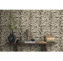 Vue d'une pièce avec du papier peint à motif zébré marron, décorée de vases, de livres et de décorations sur une table en bois.