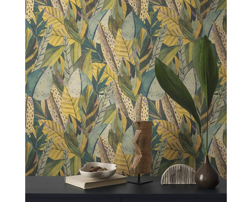 Gros plan d'un mur avec du papier peint à motif de feuilles et des objets décoratifs sur une table.