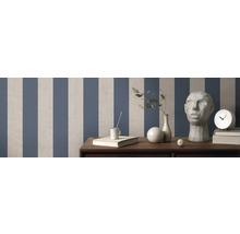 Pièce avec papier peint rayé, décorations et meubles sur surface en bois.