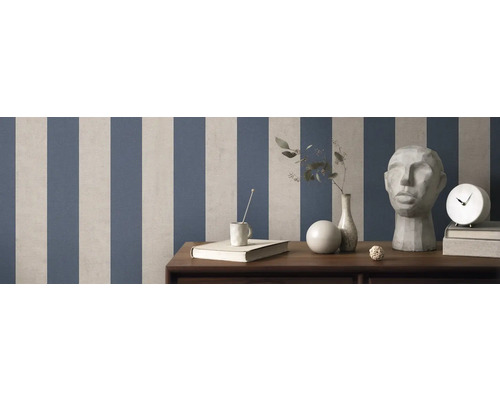 Pièce avec papier peint rayé, décorations et meubles sur surface en bois.