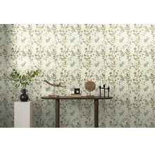 Pièce lumineuse avec papier peint à feuilles et décorations sur une table en bois.