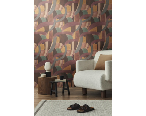 Salon avec papier peint à motifs, fauteuil, tapis et décorations