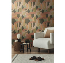 Salon avec papier peint à motifs, fauteuil et décorations sur tables d'appoint