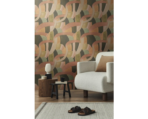 Salon avec papier peint à motifs, fauteuil et décorations sur tables d'appoint