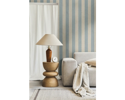 Salon avec lampe sur table d'appoint, canapé, coussins et tapis