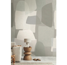 Wohnraum mit Tapete in abstrakten Formen, Tischleuchte, Beistelltisch und Sofa