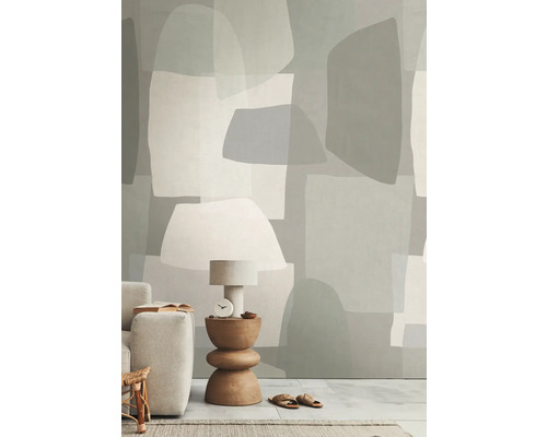 Wohnraum mit Tapete in abstrakten Formen, Tischleuchte, Beistelltisch und Sofa