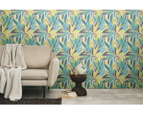 Vue d'une pièce avec du papier peint à motifs floraux, un canapé, une table d'appoint et des décorations.