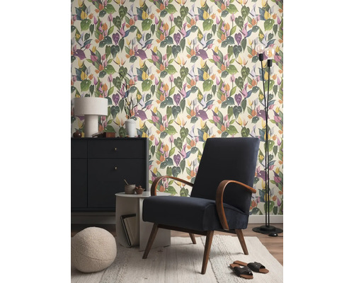 Salon avec papier peint à motifs, fauteuil, lampadaire et commode