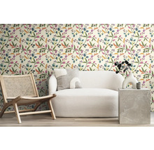 Salon avec papier peint à motifs, fauteuil et canapé pour une ambiance cosy.