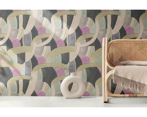 Szene mit einer gemusterten Tapete, einer Vase und einem Rattansessel