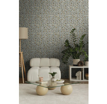 Dekorierter Raum mit einer Wand mit Tiermuster-Tapete, einem Sessel, einem Couchtisch und einer Stehlampe.