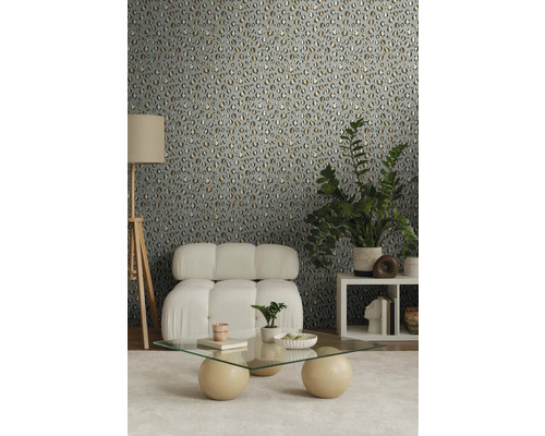 Dekorierter Raum mit einer Wand mit Tiermuster-Tapete, einem Sessel, einem Couchtisch und einer Stehlampe.