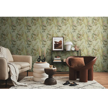 Wohnzimmer mit Sofa, Sessel, Teppich und Deko vor einer Wand mit Dschungeltapete