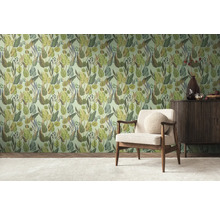 Une pièce avec un mur tapissé de motifs de jungle, un fauteuil et un buffet.