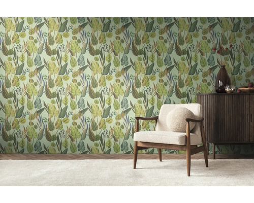 Une pièce avec un mur tapissé de motifs de jungle, un fauteuil et un buffet.