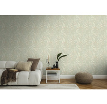 Wohnzimmer mit Tapete mit Blattmuster, Sofa, Beistelltisch und Pouf