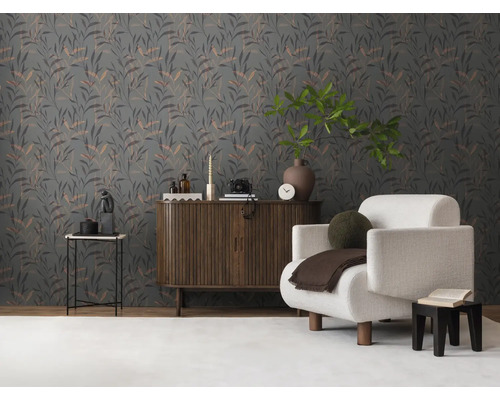 Wohnzimmer mit floraler Tapete, Sessel und Holzkommode