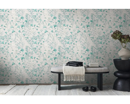 Dekoratives Interieur mit einer Wandtapete mit Blattmuster, Bank und Beistelltisch mit Blumenvase