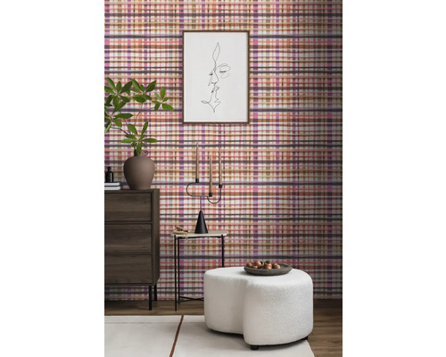 Intérieur de salon avec papier peint à carreaux, commode, tabouret et décorations pour une ambiance cosy.