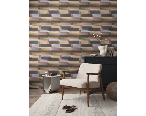 Wohnzimmer mit gemusterter Tapete, Sessel und Teppich