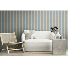 Scène de salon avec fauteuil, canapé et table d'appoint devant un mur rayé