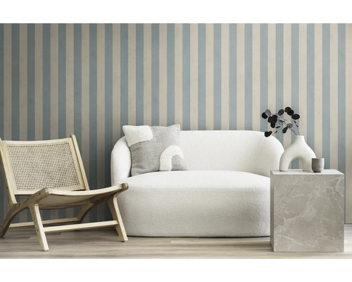 Scène de salon avec fauteuil, canapé et table d'appoint devant un mur rayé