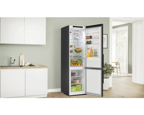 Kühlschrank mit Gefrierfach in einer hellen Küche mit geöffneter Tür und Lebensmitteln