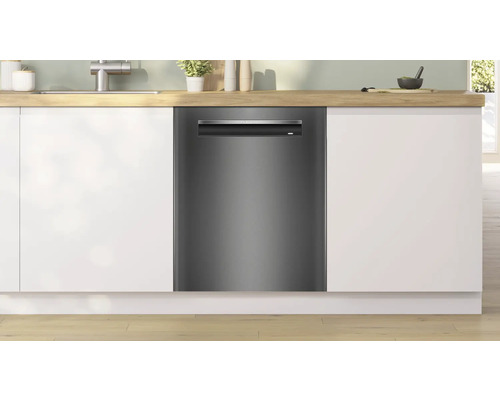 Lave-vaisselle dans une cuisine moderne avec des armoires blanches et un plan de travail en bois