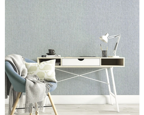 Helles Arbeitszimmer mit Schreibtisch, Stuhl und Lampe vor einer strukturierten Tapete