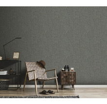 Wohnraum mit grauer Tapete, Sessel und Beistelltisch