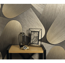 Dekorative Tapete mit geometrischem Muster hinter einem Tisch mit Blumenvase, Fotorahmen und Armbanduhr