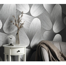 Szene mit einer Tapete mit abstraktem Muster, einem Beistelltisch mit Dekoration und einem Sessel