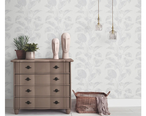 Wohnraum mit gemusterter Tapete, Kommode, Dekoration und Beleuchtung