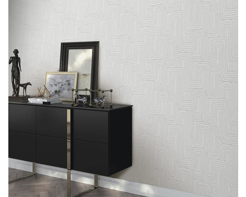 Wohnszene mit einer schwarzen Kommode und einer Tapete mit geometrischem Muster
