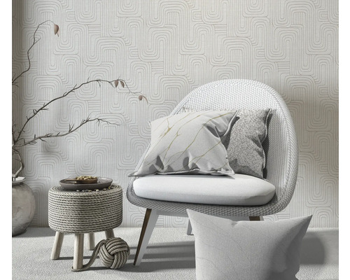 Dekorative Szene mit Stuhl, Kissen und gemusterter Tapete für eine helle und organisierte Raumatmosphäre.