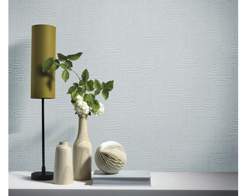 Zimmer mit gemusterter Tapete, Lampe und dekorativen Objekten