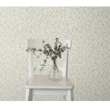 Dekorative Tapete mit Blattmuster, kombiniert mit einem Stuhl und einer Vase mit Zweigen für ein stilvolles Raumambiente.