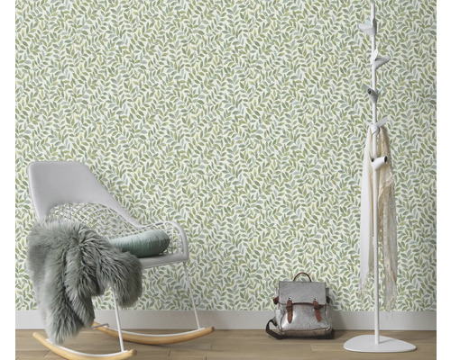 Zimmer mit einer Tapete mit Blattmuster, einem Schaukelstuhl und einer Garderobe.