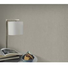 Gros plan d'un papier peint structuré dans un salon avec lampe et décoration.