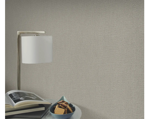 Gros plan d'un papier peint structuré dans un salon avec lampe et décoration.