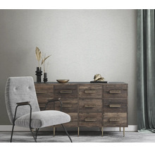 Salon avec fauteuil, commode et papier peint à motifs floraux