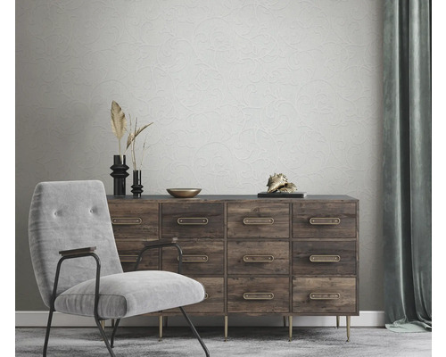 Salon avec fauteuil, commode et papier peint à motifs floraux