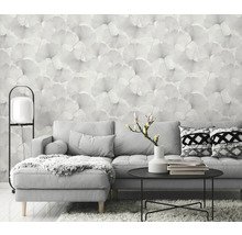 Wohnzimmer mit grauer Couch, Tisch und floraler Tapete